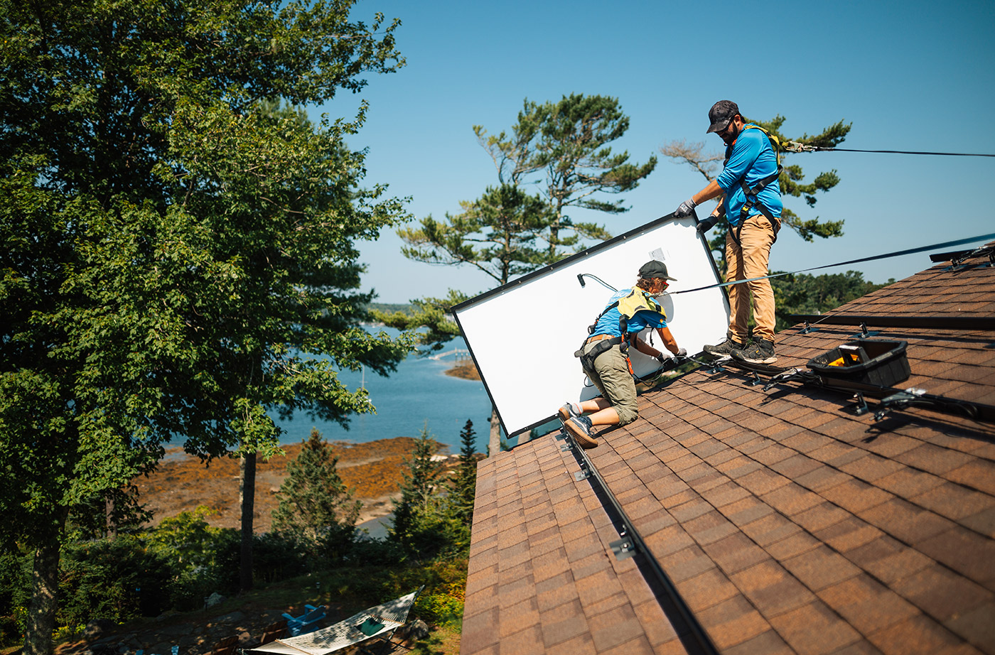two people on roof installing solar panel