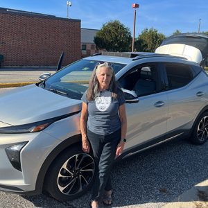 woman standing in front of her silver car