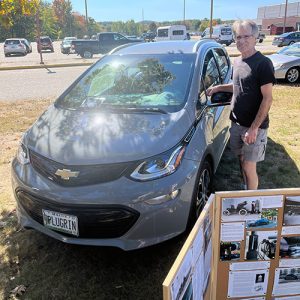 man standing next to Chevy car
