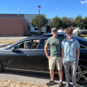 man and teenage son standing in front of Mercedes sedan