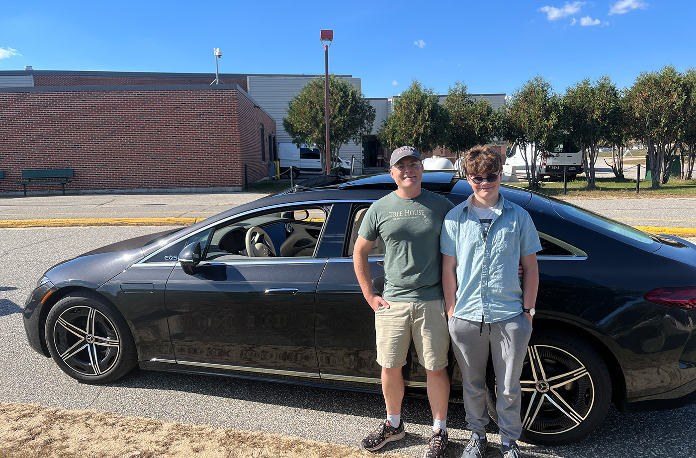 man and teenage son standing in front of Mercedes sedan