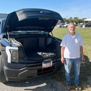 man standing next to truck with hood up