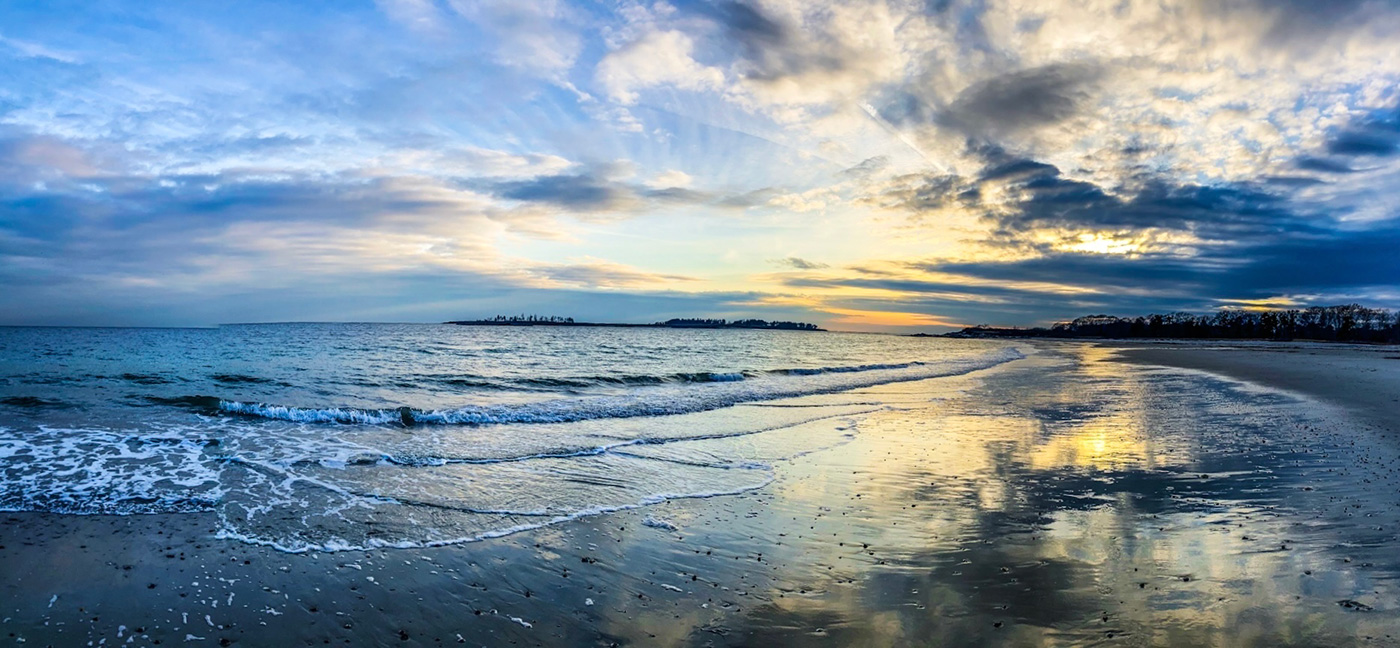 beautiful sun bursting through cloud over calm water 