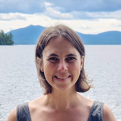 Emmie smiling in front of lake and mountains