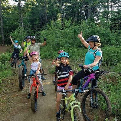 Nell-and-kids adults and children biking on trail