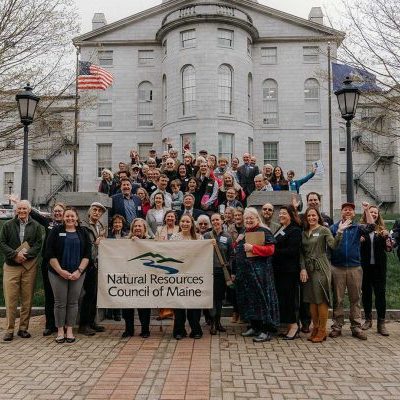 NRCM members standing on stairs with Maine State House behind them